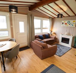 A living room with a sofa and dining table at Moggs Retreat in Chapel St Leonards