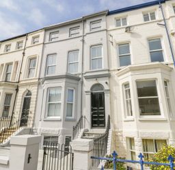A row of terraced houses with stairs leading to the door at Station House in Scarborough
