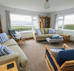 A living room with sofas and bookshelf at Yr Orsedd in Llanfaethlu