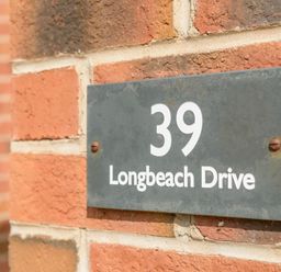 A house number sign displaying 39 Longbeach Drive mounted on a brick wall at 39 Longbeach Drive in Beadnell