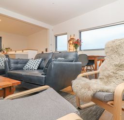 A living room with leather sofas a wooden coffee table and a dining table with chairs at Idlewild 2 Wheal Turnavore in St Agnes