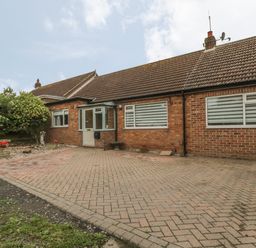 A single-story brick house with a tiled roof and a paved driveway at 2 The Close in Robin Hoods Bay