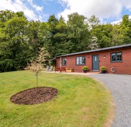 A cabin surrounded by grass and trees at Ryedale Country Lodges - Hazel Lodge Kirkbymoorside
