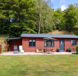 A log cabin with a patio and outdoor seating at Ryedale Country Lodges - Willow Lodge in Kirkbymoorside