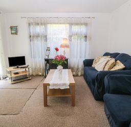 A living room with a sofa and coffee table at Castell Chalet Penrhos near Pwllheli