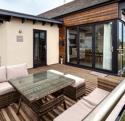 An outdoor patio area with a sofa and coffee table at Cowslip in Bamburgh