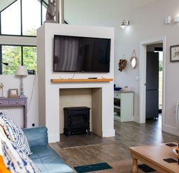 A living room with a television above a fireplace at Betony in Bamburgh
