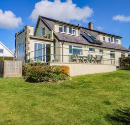 A house with a balcony and garden at Pen Y Garth in Mynytho near Llanbedrog