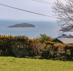 A coastal view with an island in the sea at Pen Y Garth Mynytho near Llanbedrog