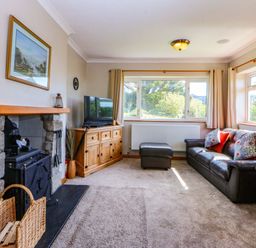 A living room with a sofa and television at Pen Y Garth, Mynytho near Llanbedrog