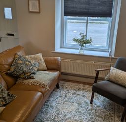 A living room with a sofa and chair at Troopers Cottage in Frome