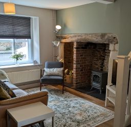 A living room with a sofa and fireplace at Troopers Cottage in Frome