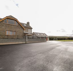 A house with stone and grey walls a paved driveway and a small soccer goal in a field at Grooms Quarters at Pant y Gaseg Farm in Ammanford