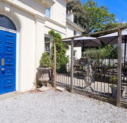 An outdoor area with a blue door and patio furniture at Holcombe House in Torquay