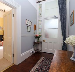 A hallway with a table and flowers at Holcombe House in Torquay