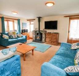 A living room with sofas and a fireplace at The Shippon in Barnstaple