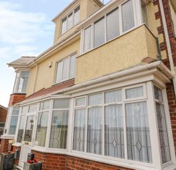 The front exterior of a multi-story house with tiled roof and windows with decorative glass at The Gansey Girl in Bridlington