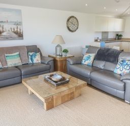 A living room with two sofas and a coffee table at Sandpiper in Perranporth