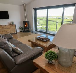 A living room with a sofa and coffee table at Sandpiper in Perranporth
