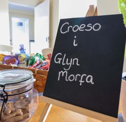 A welcome sign and snacks in a kitchen at Glyn Morfa Harlech