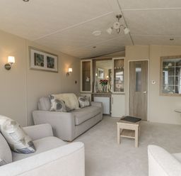 A living room with two sofas a small table a cabinet with glass doors and a door at The Sequoia in Cloughton