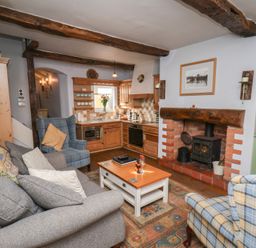 A living room with a sofa and fireplace at Cobbles House in Whitby