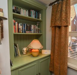 A reading nook with a bookshelf and lamp at Cobbles House Whitby