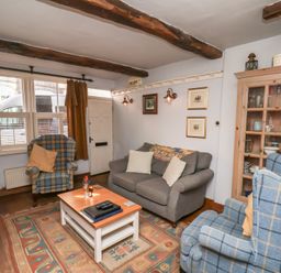 A living room with a sofa and armchairs at Cobbles House in Whitby