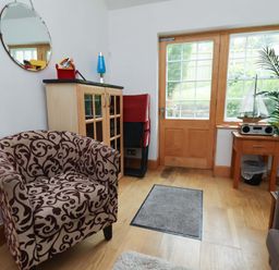 A snug with a chair and a plant at Damson Cottage in Whitby