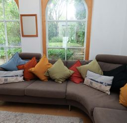 A living room with a sofa and cushions at Damson Cottage in Whitby