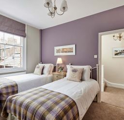 A bedroom with two single beds and a bedside table with a lamp at Harbour House in Whitby