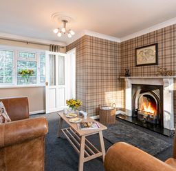 A living room with a fireplace coffee table and leather armchairs at Esk View Cottage in Grosmont