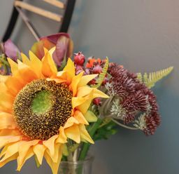 A bouquet with a large sunflower and other flowers in a glass jar at Church View in Whitby