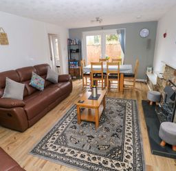 A living room with a sofa and dining table at Ty'r Winllan in Newport, Pembrokeshire