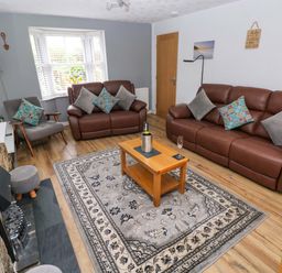 A living room with sofas and a coffee table at Ty'r Winllan in Newport, Pembrokeshire