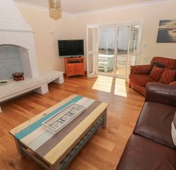 A living room with a fireplace television couches and a coffee table at Yr Hen Ardd in Dale near Milford Haven