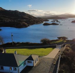 A house with a driveway and gate near water at Ranny Roe in Portsalon, County Donegal