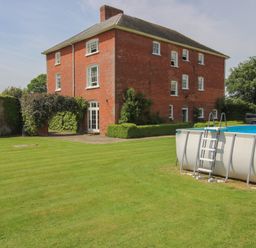 A house with a pool and lawn at Hilltop House in Tenbury Wells