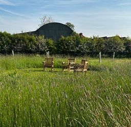A garden with chairs and a table in the grass at Keepers Cottage in West Knoyle