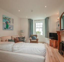 A living room with a TV and a fireplace at Beachcomber in Padstow