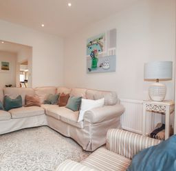 A living room with a sofa and lamp at Beachcomber in Padstow