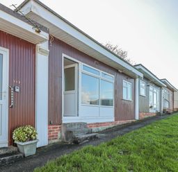 Exterior view of single-story units with numbered doors and small concrete steps at 304 Norton Park in Dartmouth