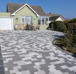 A driveway with a patterned surface and outdoor table set in front of a house at Rosamond in Shipton Gorge