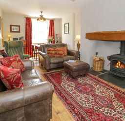 A living room with a sofa and fireplace at Sygun View in Beddgelert