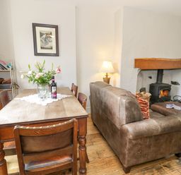 A dining room with a table, chairs, and a sofa at Sygun View in Beddgelert