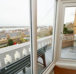 A balcony with a view of houses and water at Preswylfa Caernarfon