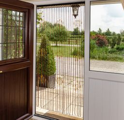 An entrance with a wooden door and beaded curtain at Willow Barn Cucklington near Wincanton
