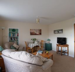 A living room with sofa armchairs coffee table TV and dining table at Little Barn Cucklington near Wincanton