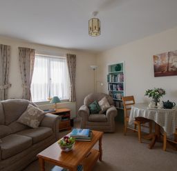 A living room with sofa armchair wooden table and dining table with chairs at Little Barn in Cucklington near Wincanton