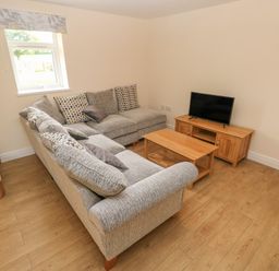 A living room with a corner sofa coffee table and television at Woodpecker Barn in Hensol near Pontyclun